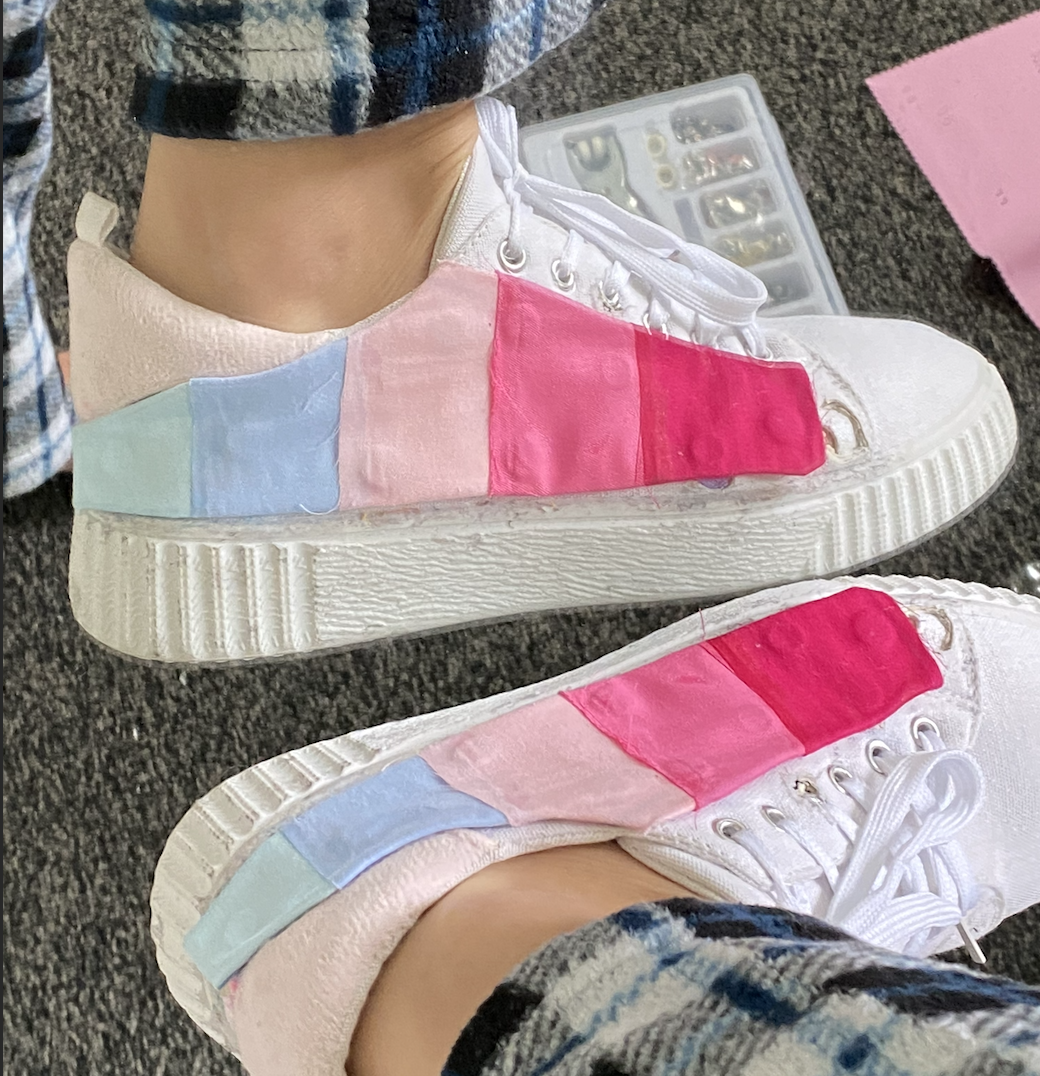 Pair of sneakers with pink to blue gradient panels being worn