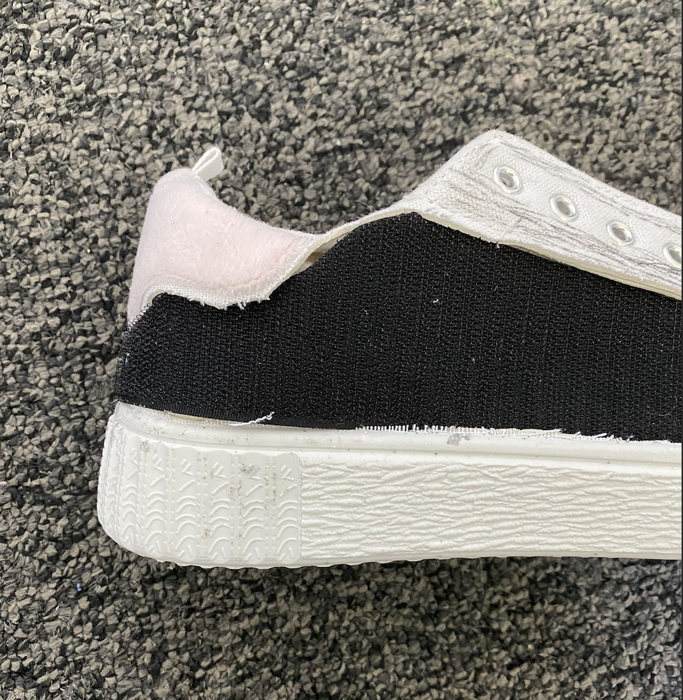 Close-up of frayed canvas and worn velcro edge on a shoe