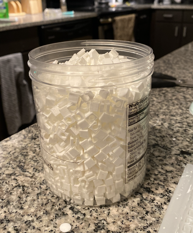 Large container full of hand-cast bead pieces