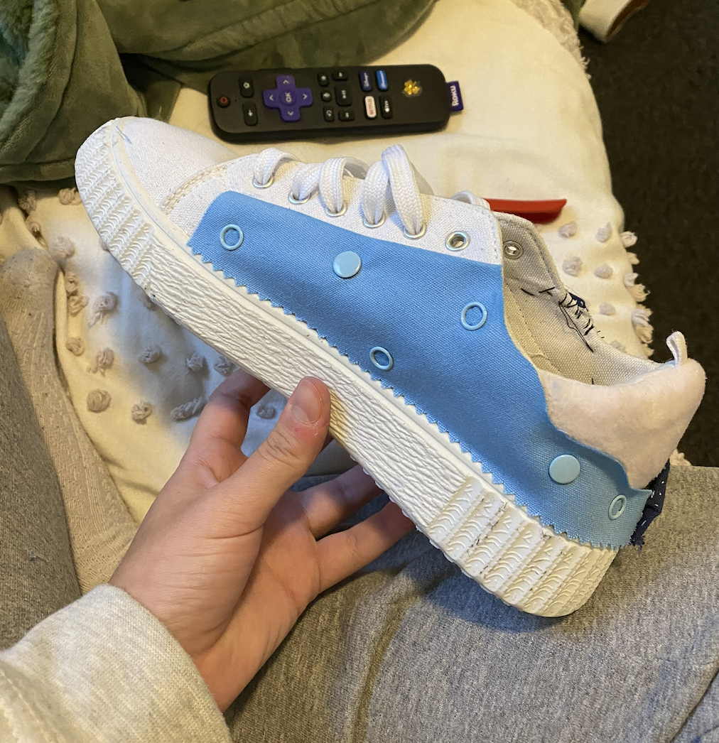 White sneaker with a light blue snap-on side panel